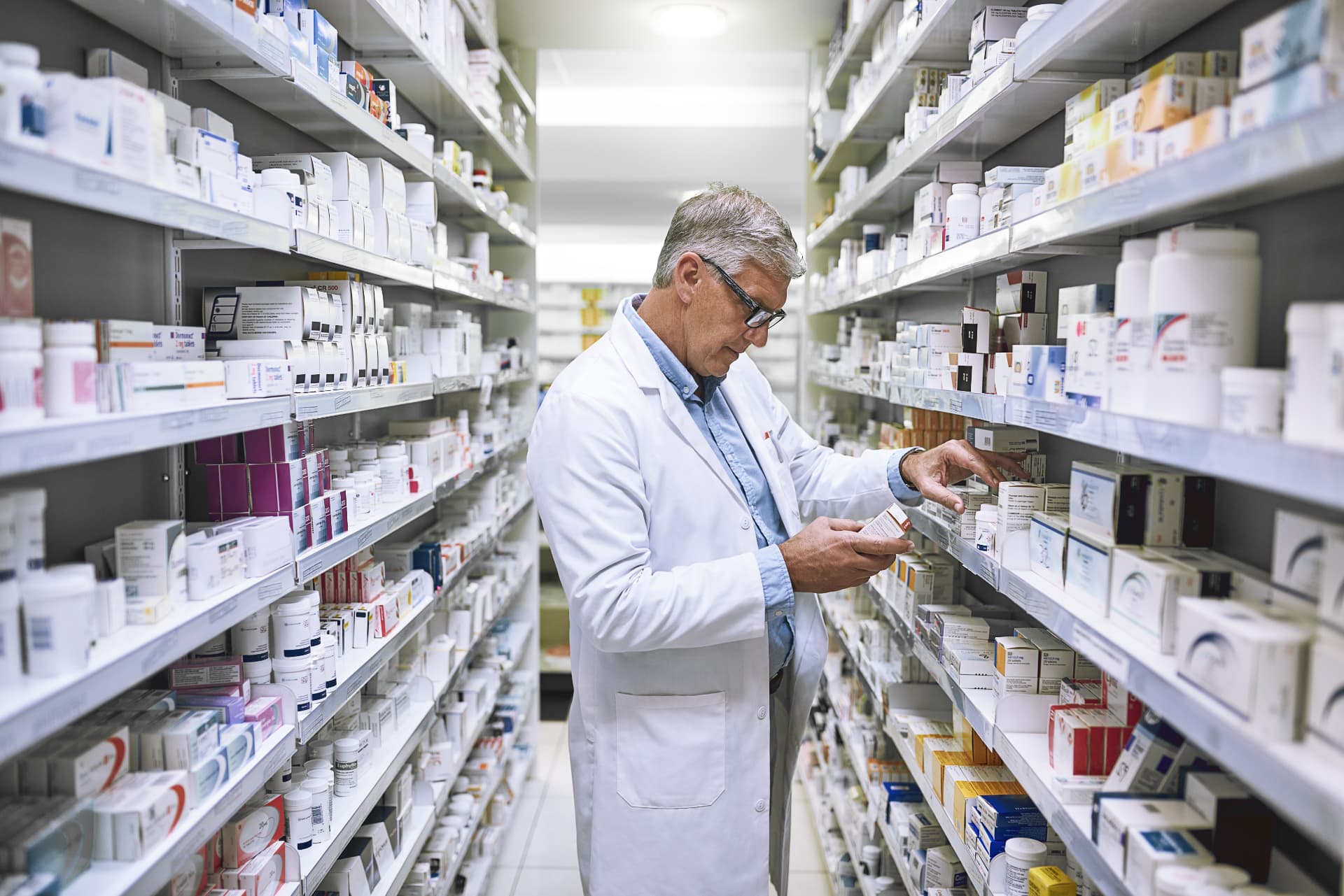 Apotheker prüft kühlpflichtige Arzneimittel im Kommissionierregal