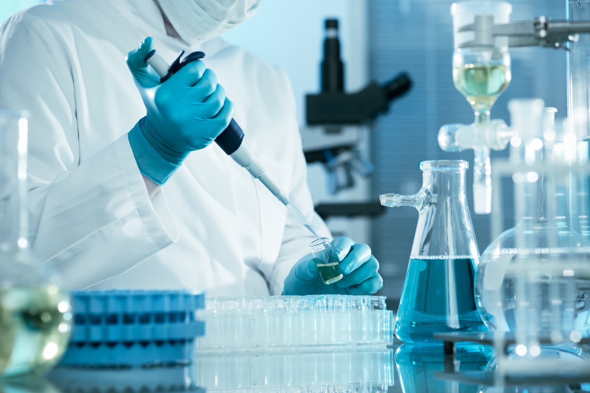 Laborfachkraft pipettiert eine Probe für den gekühlten Diagnostikversand